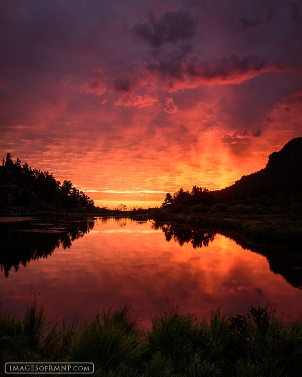 The sky puts on an incredible show at the start of a new day at Lily Lake, Rocky Mountain National Park.